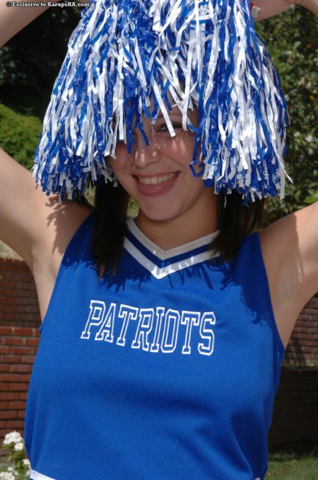 Busty teenage cheer girl Holly Webster takes off her blue uniform right in the sun