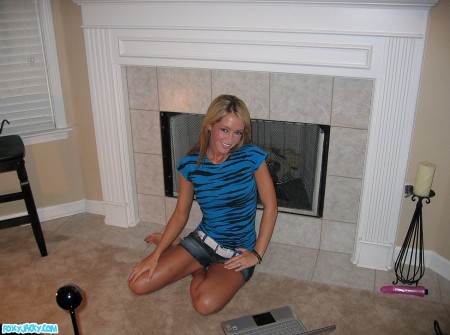 Giggling blonde chick Foxy Jacky strips and toys her sexy hairless pussy at the fireplace